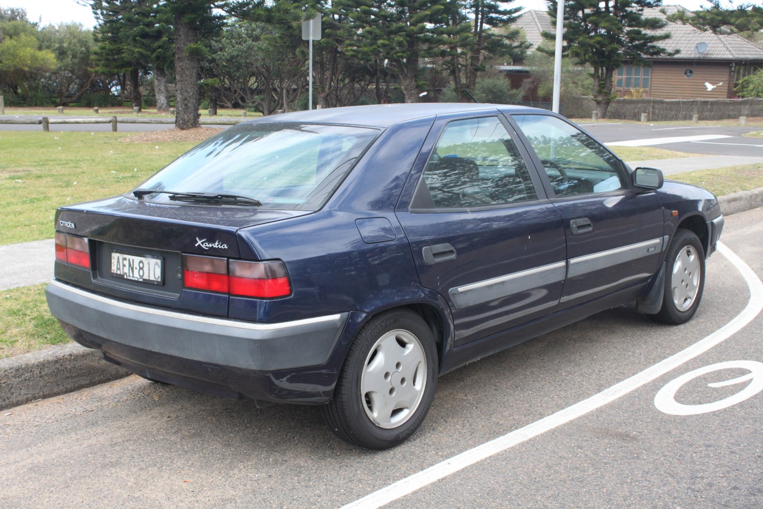 Rear and side exterior view of a 1990s sedan with distinctive taillights and body lines.
