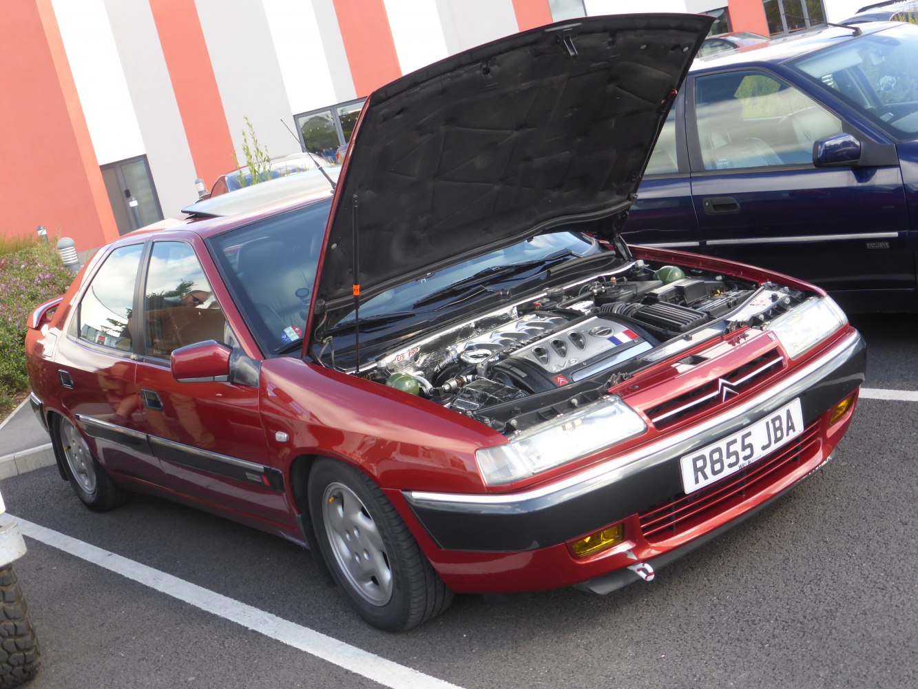 Open hood showing front engine bay and front fascia of a 1990s hatchback.