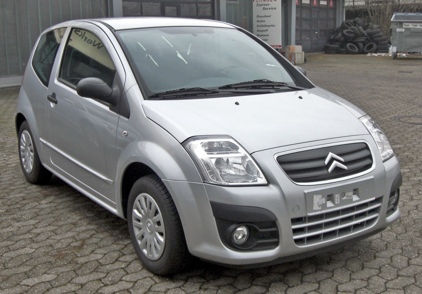 Compact hatchback front view with headlights and grille