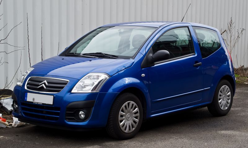 Compact hatchback front side view in blue with distinct grille and headlight design
