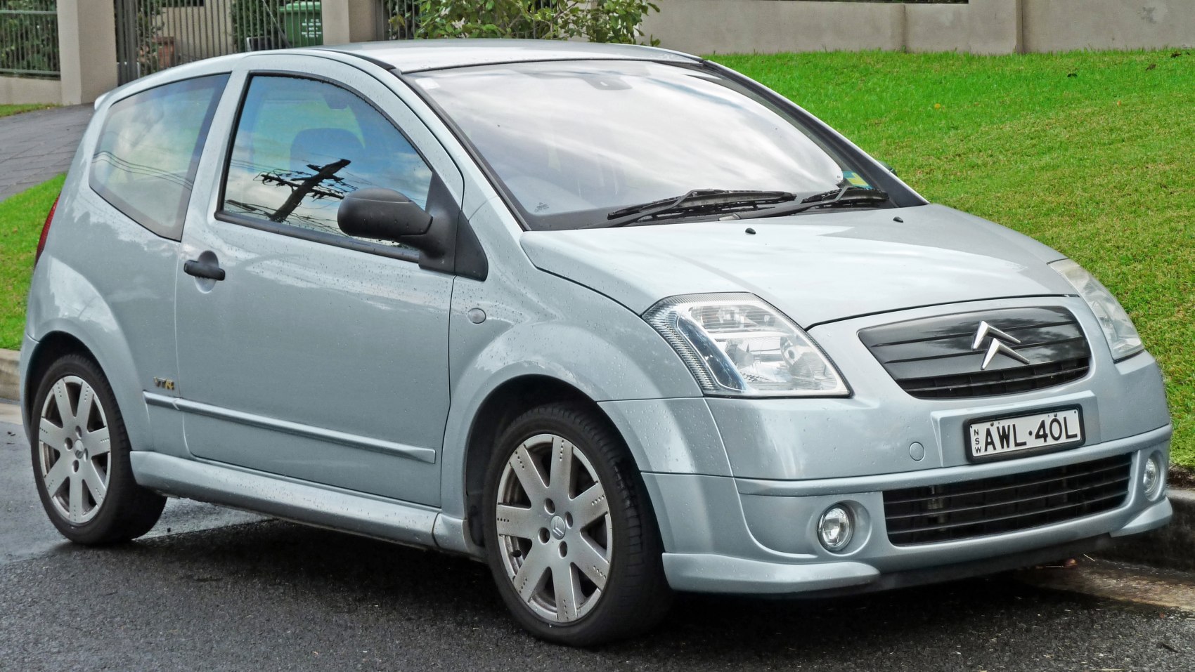 Front side view of compact hatchback with alloy wheels and headlights