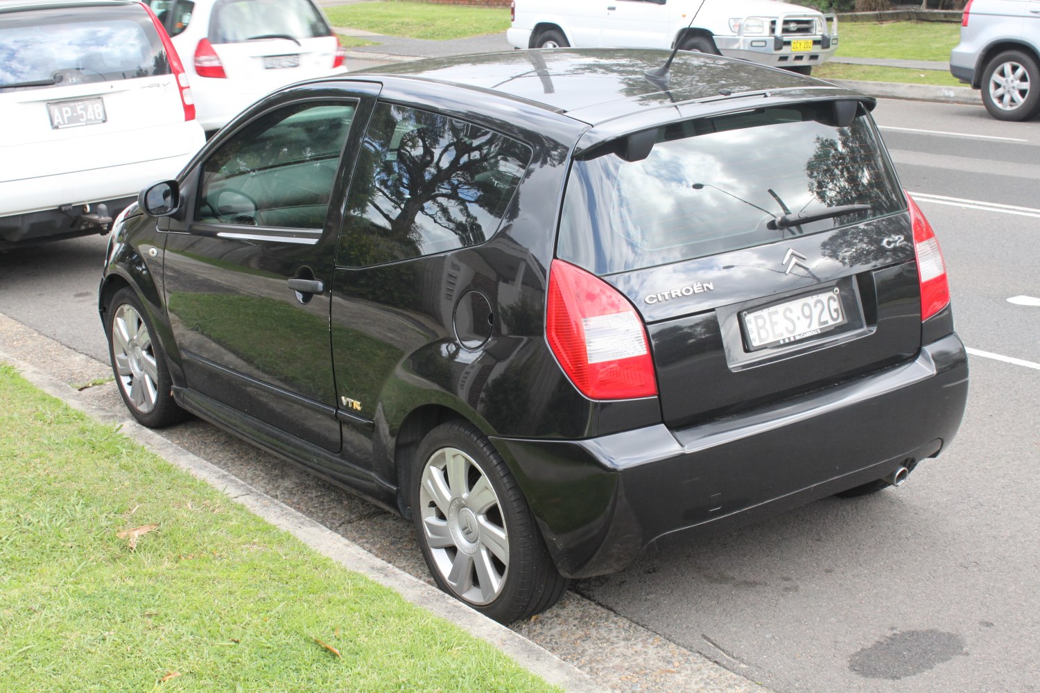 rear side view of compact hatchback with alloy wheels and black paint