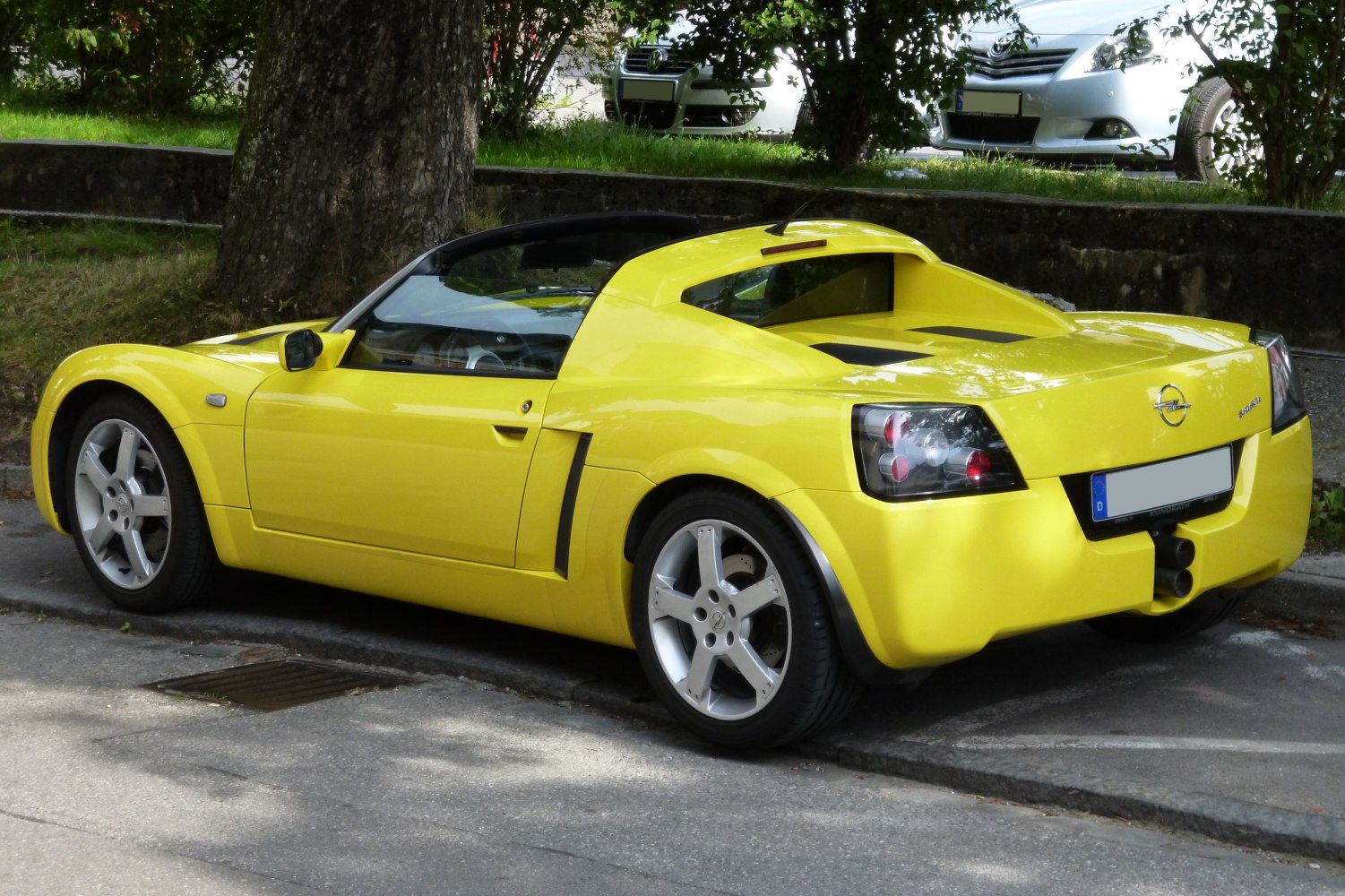 Yellow sports car rear side view with taillights and dual exhaust