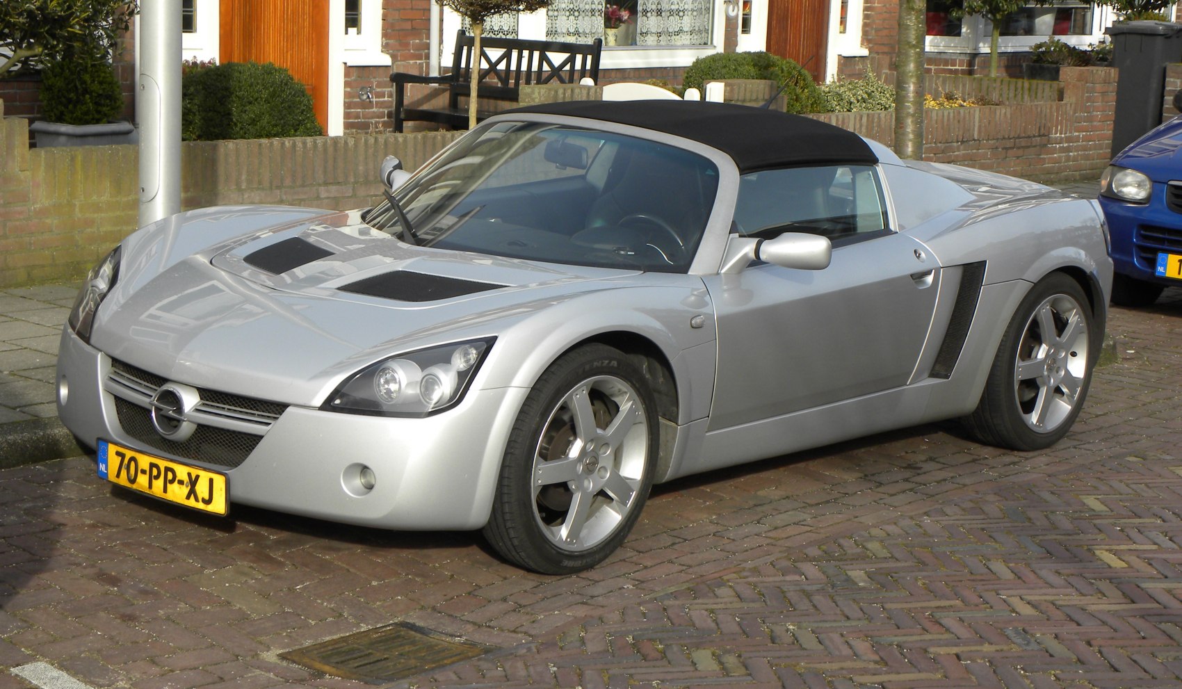 Silver convertible sports car front side view with alloy wheels and aerodynamic styling