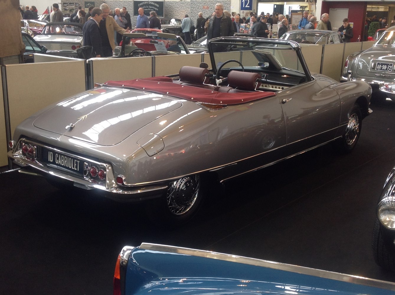 Rear view of vintage convertible with maroon interior and chrome details