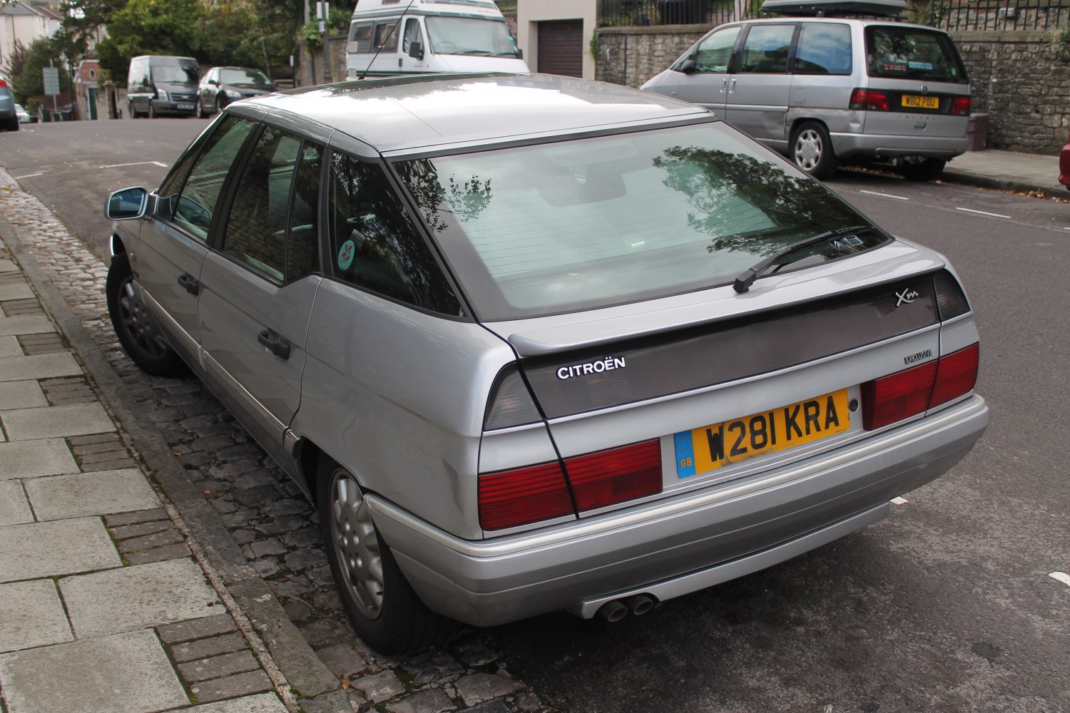Silver hatchback rear with dual exhaust and rear window wiper