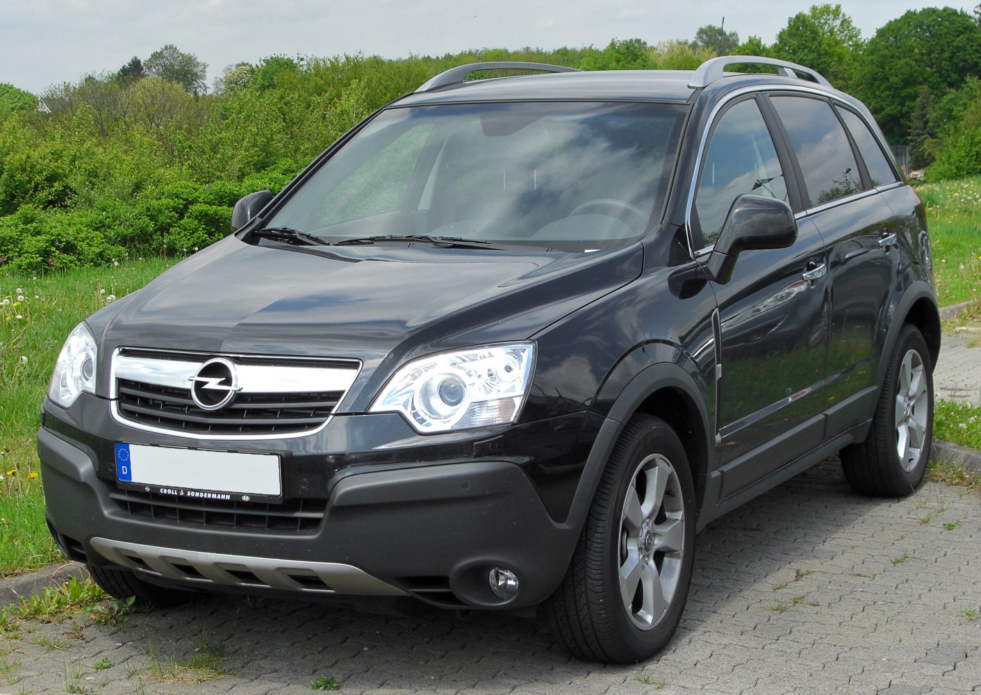 Front-side view with chrome grille and roof rails