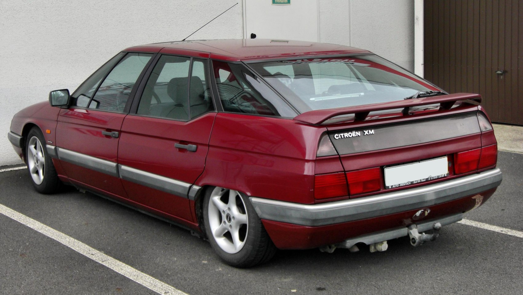 Rear side view with spoiler and distinctive tail lights.