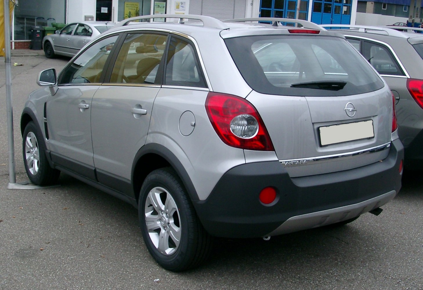 Rear and side view of silver compact SUV with visible tail lights and roof rails