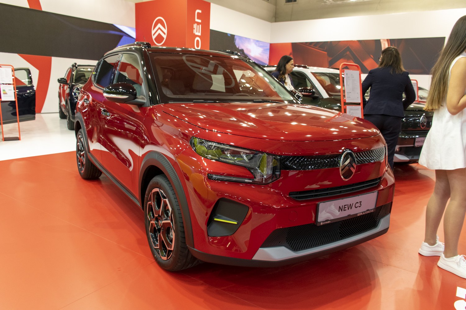 Front view of a red compact vehicle with LED headlights and distinctive grille design