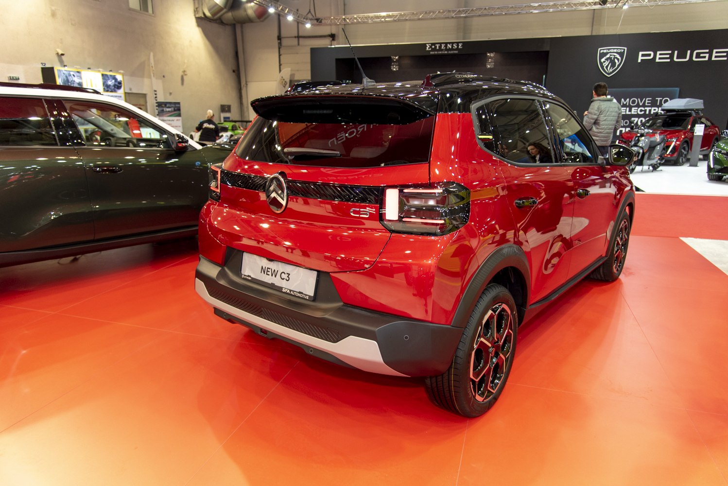 Rear view with distinctive split tail lights and sporty wheels, black roof contrast.