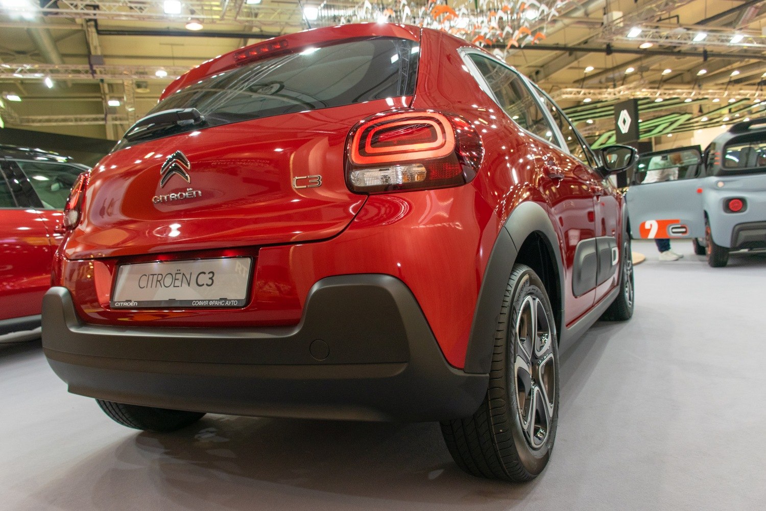 Rear angle of red compact hatchback with distinct tail lights and black bumper trim