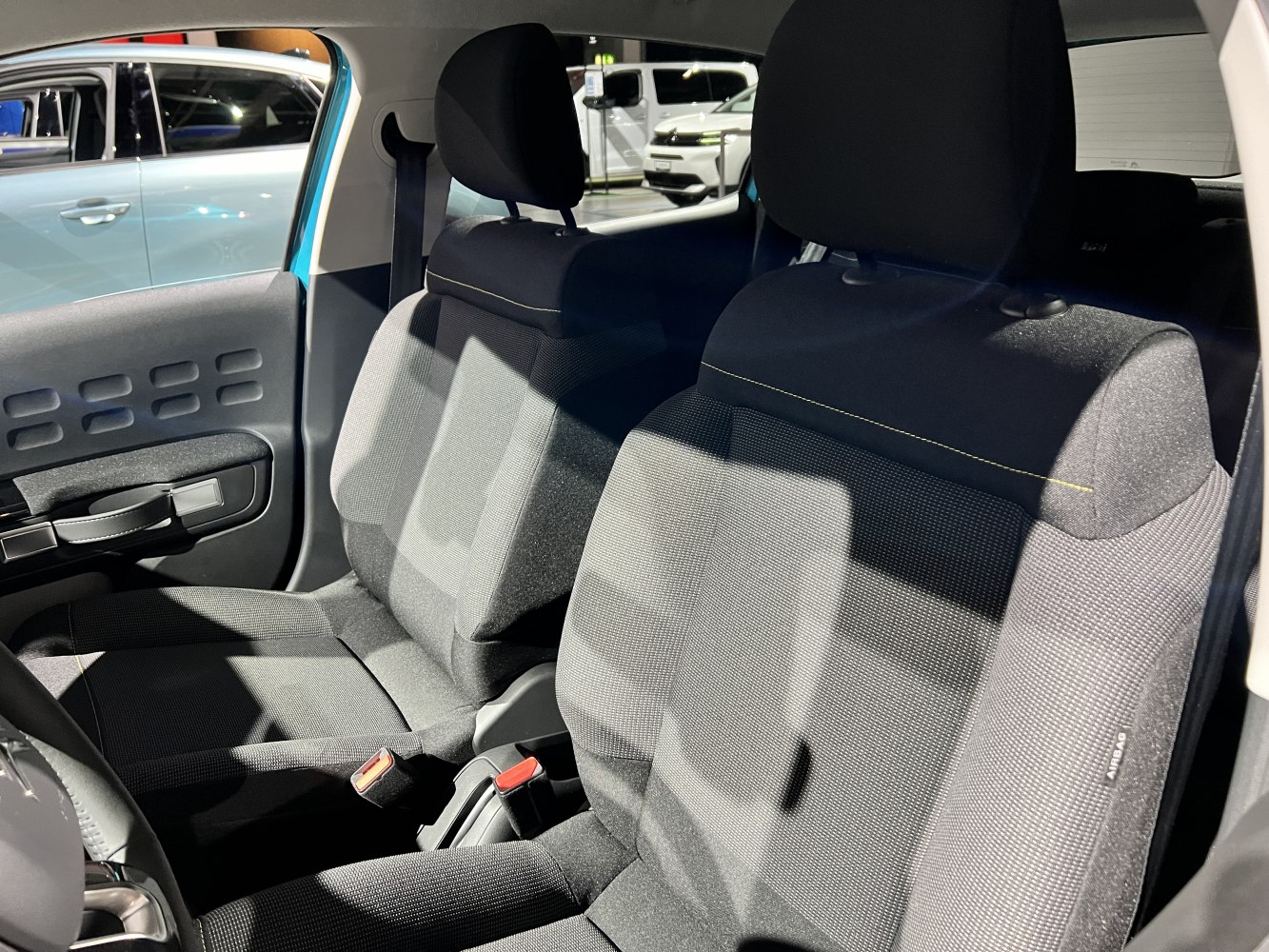 Fabric front seats and door panel interior design with seatbelts and headrests