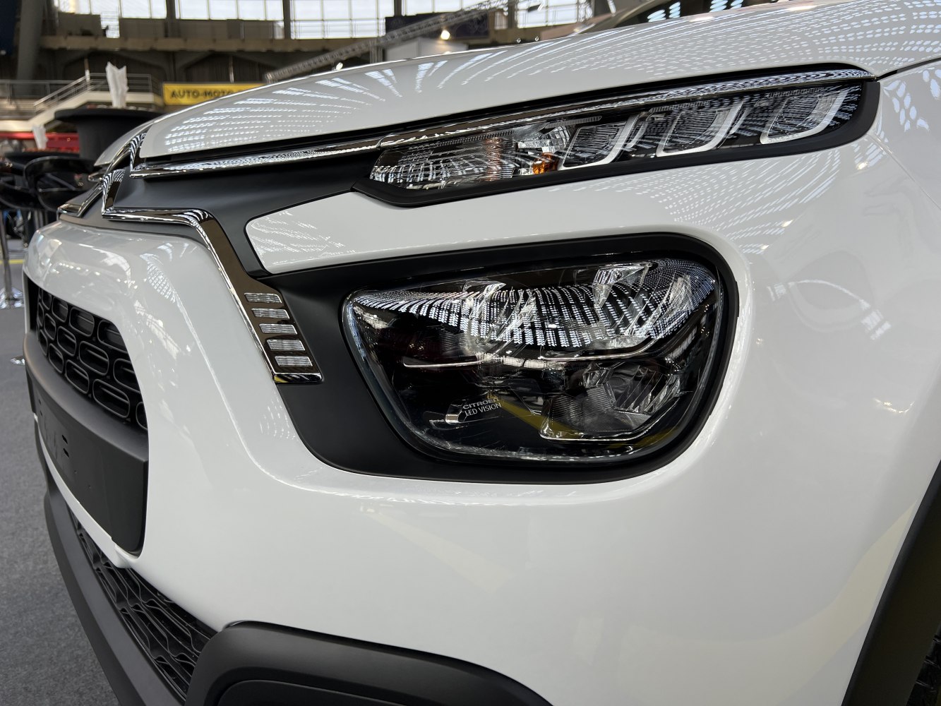 Close-up of sleek, dual-level front LED headlights with honeycomb grille