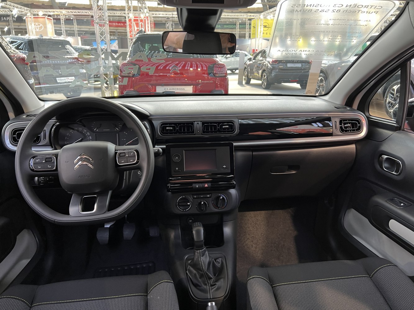 Compact car dashboard with touchscreen and multifunction steering wheel