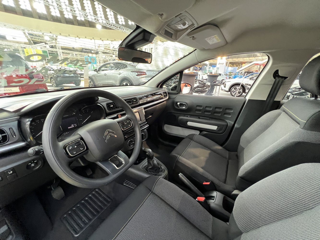 Modern dashboard and fabric front seats with steering wheel controls