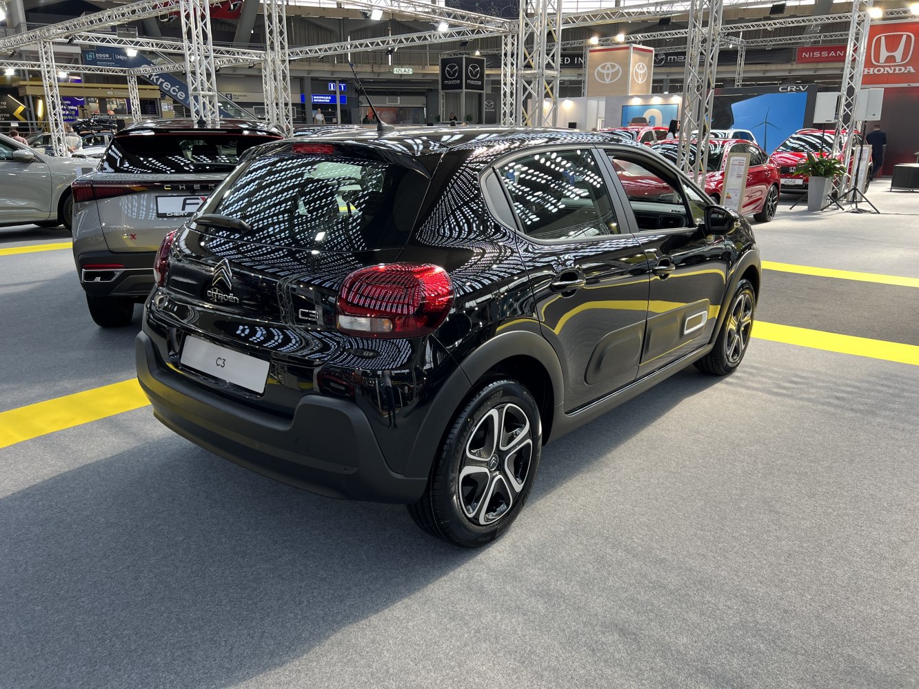 Rear and side view of a compact hatchback with unique protective side panels and modern taillights