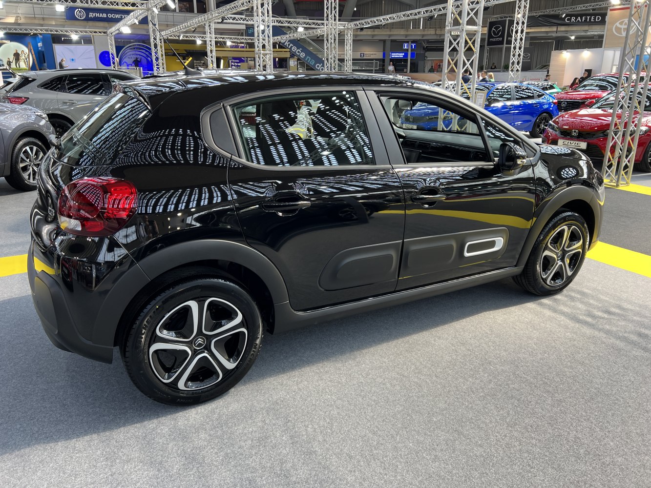 Black compact hatchback side view with door airbump and alloy wheels