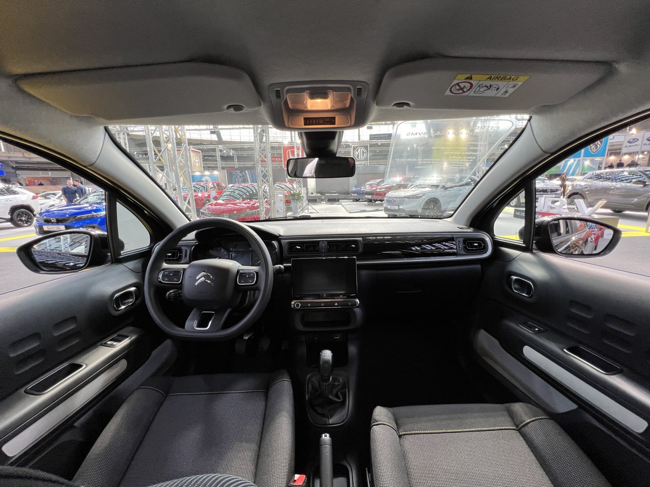 Car interior with dashboard, touchscreen, and steering wheel controls