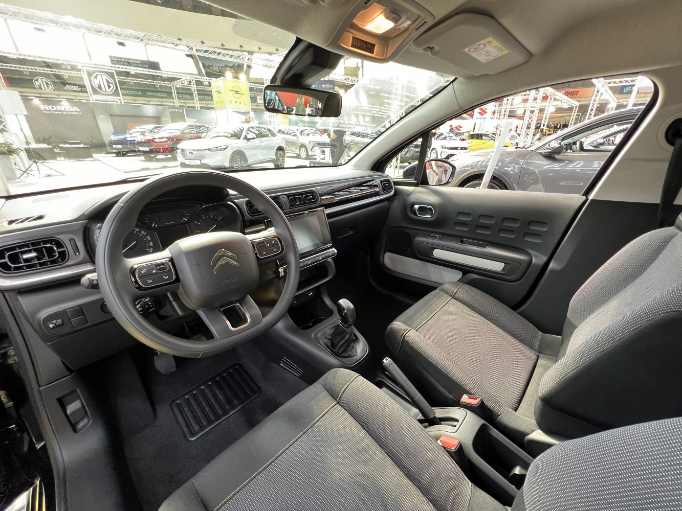 Dashboard, steering wheel, gear lever, and front seats of compact car interior