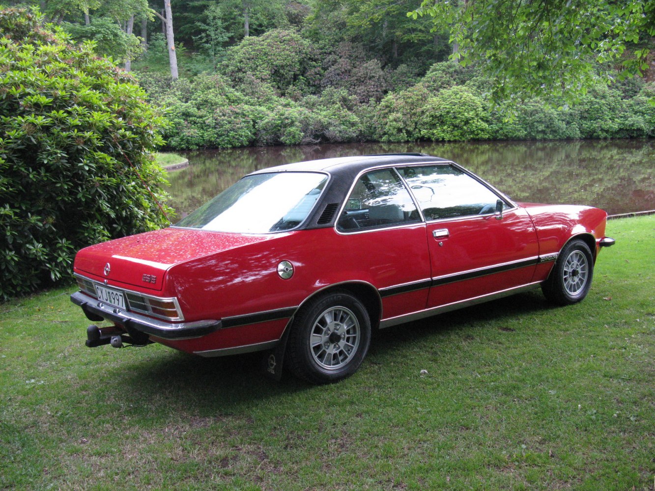 Red coupe with black vinyl roof and alloy wheels