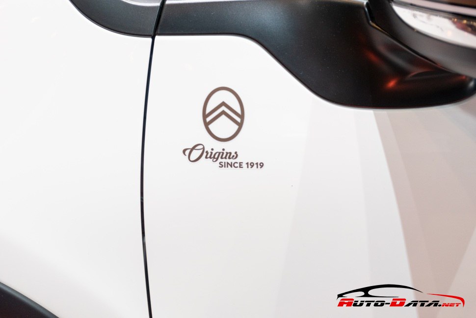 Close-up of Origins badge on car door panel with black trim