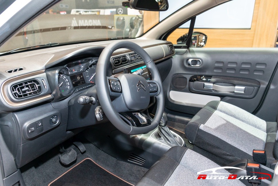 Dashboard, steering wheel, and front seats inside a compact car