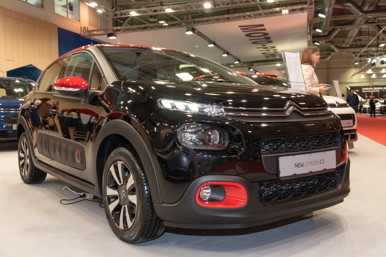 Compact hatchback with split front headlights and red accent trim