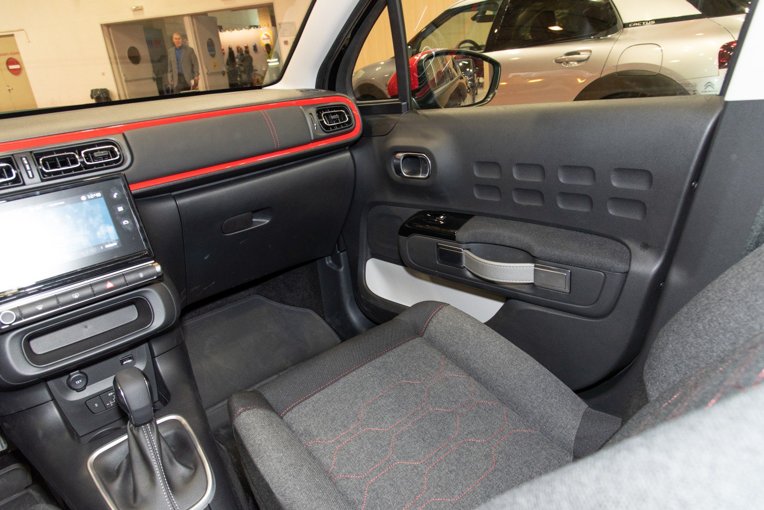 Passenger side dashboard and door panel with textile seat and red trim