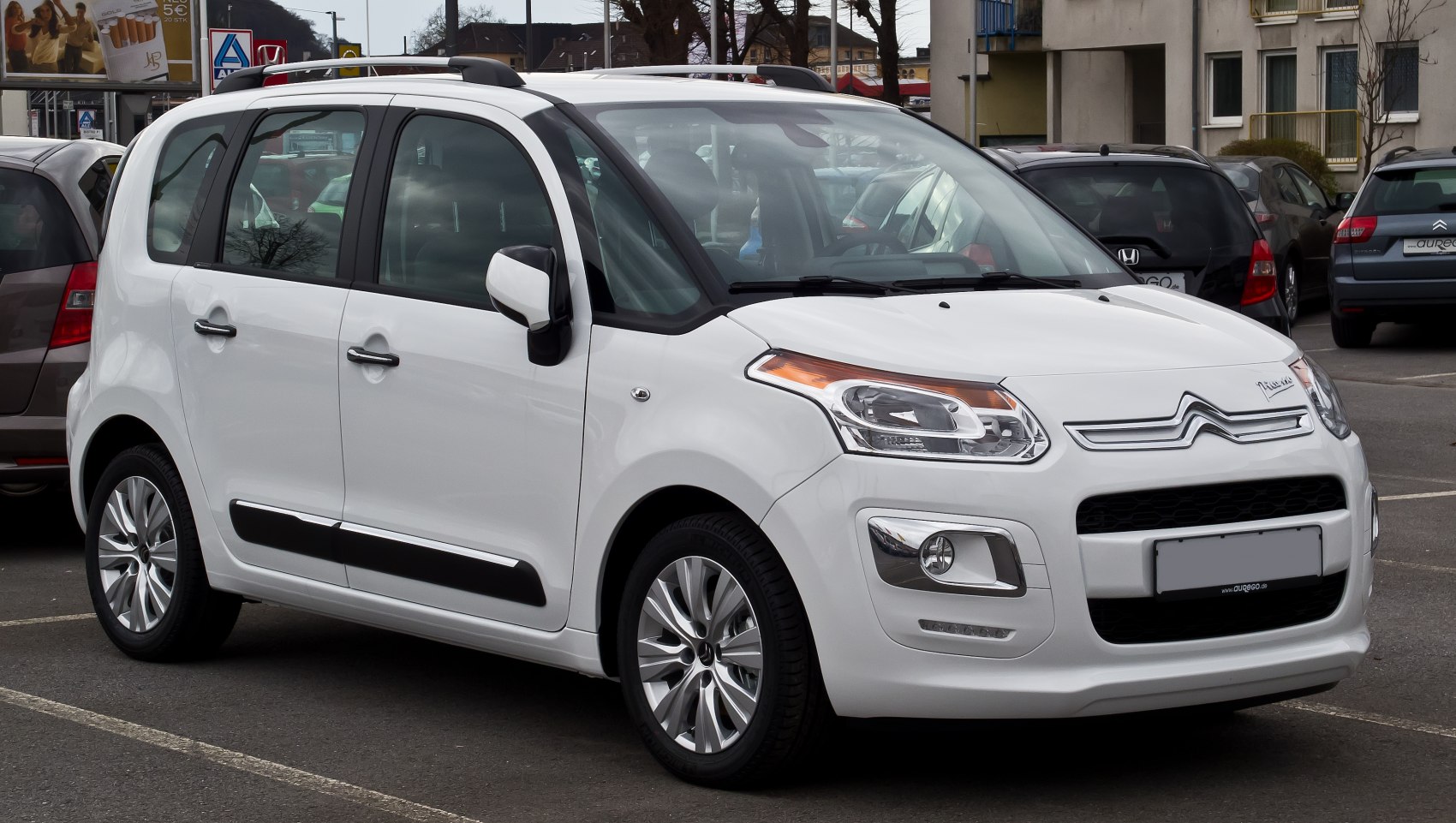 Front-side view of a compact MPV with distinctive headlight and roof rail design