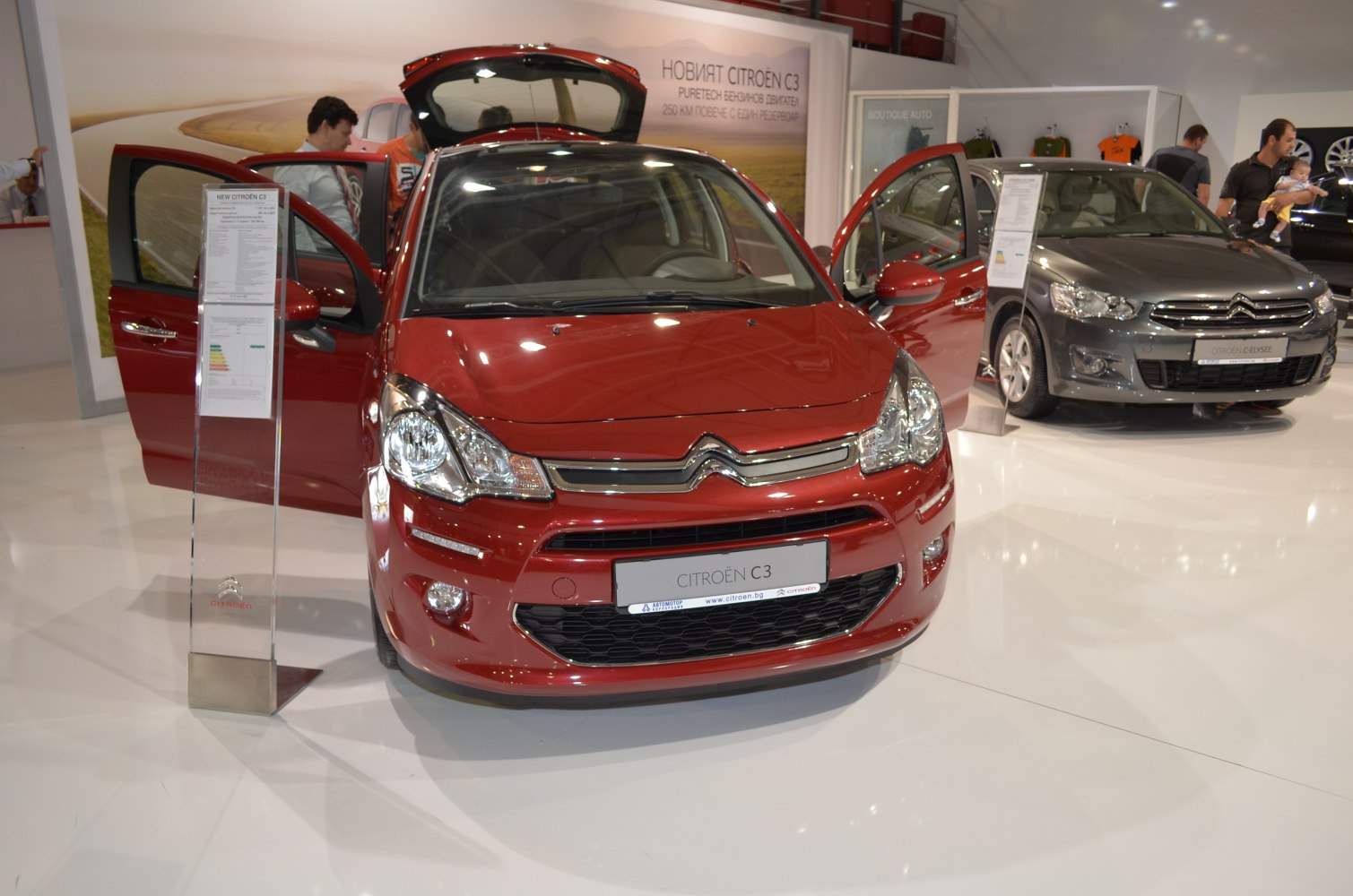 Red hatchback car with open front doors and rear hatch