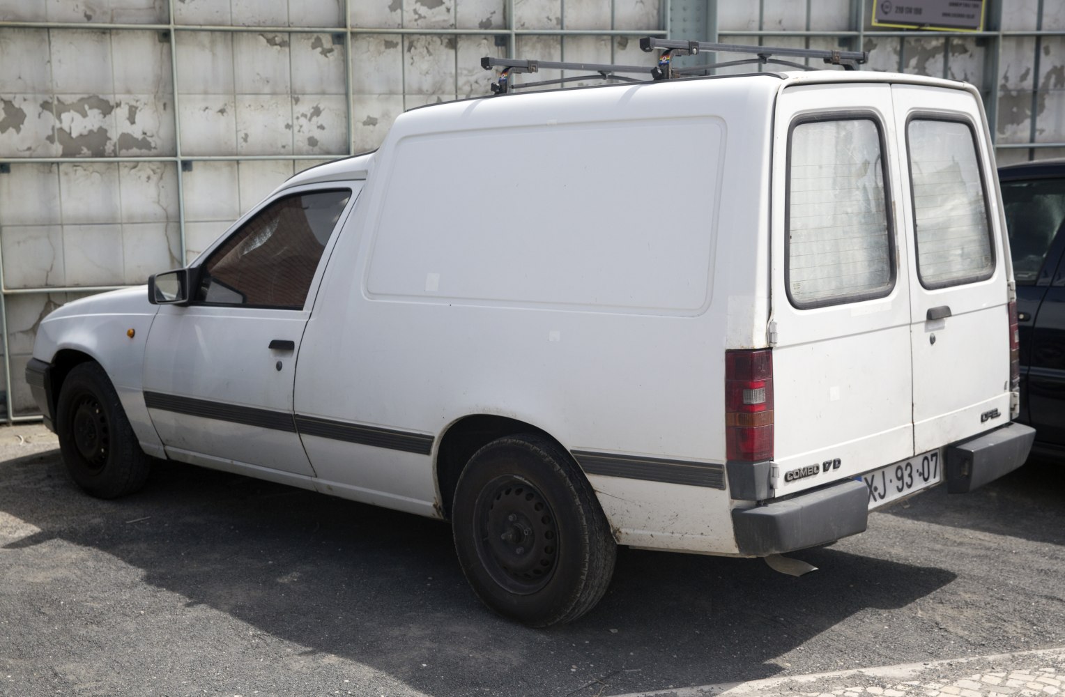 White commercial panel van with dual rear doors and roof rack