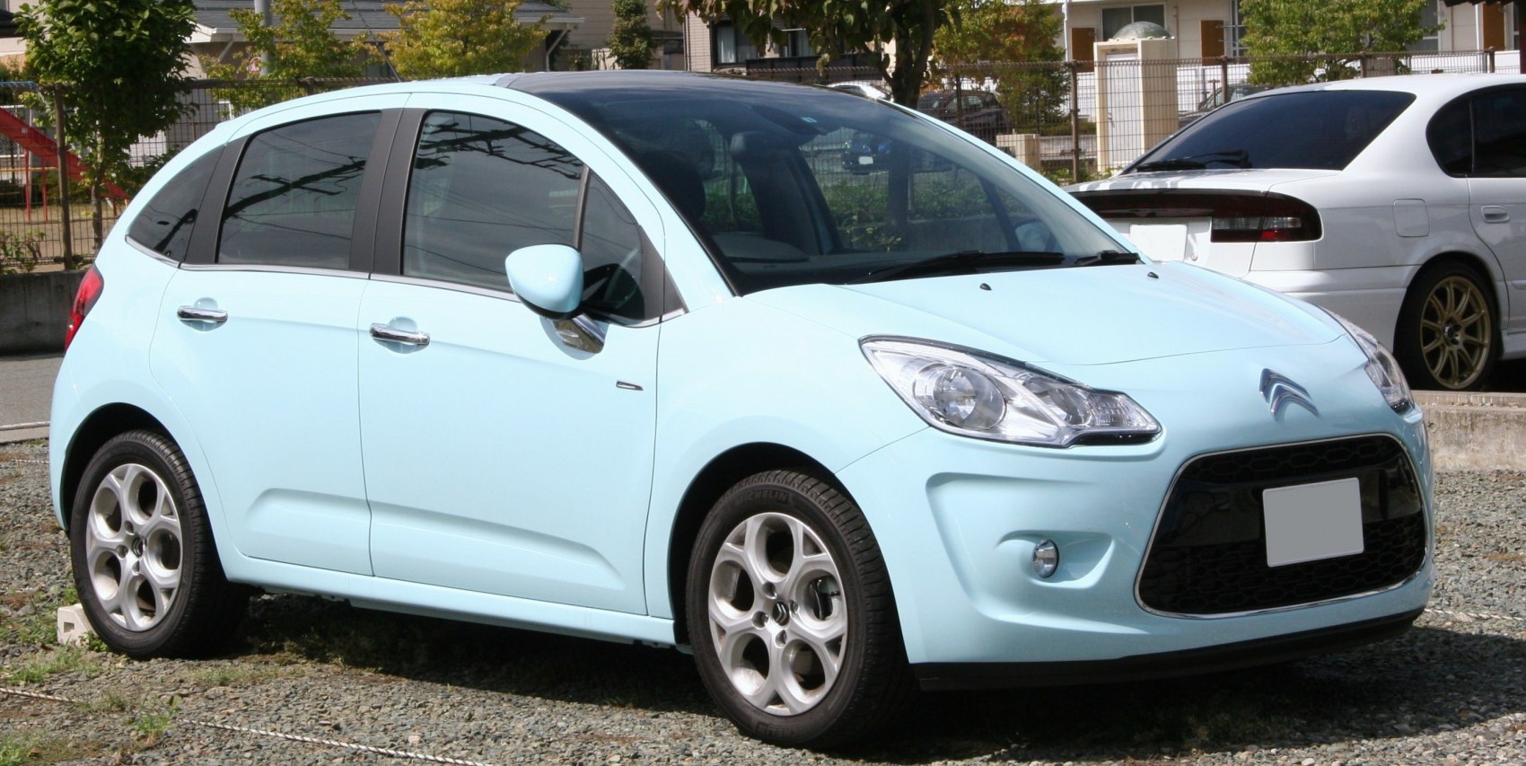Light blue compact hatchback with large front grille and rounded headlights