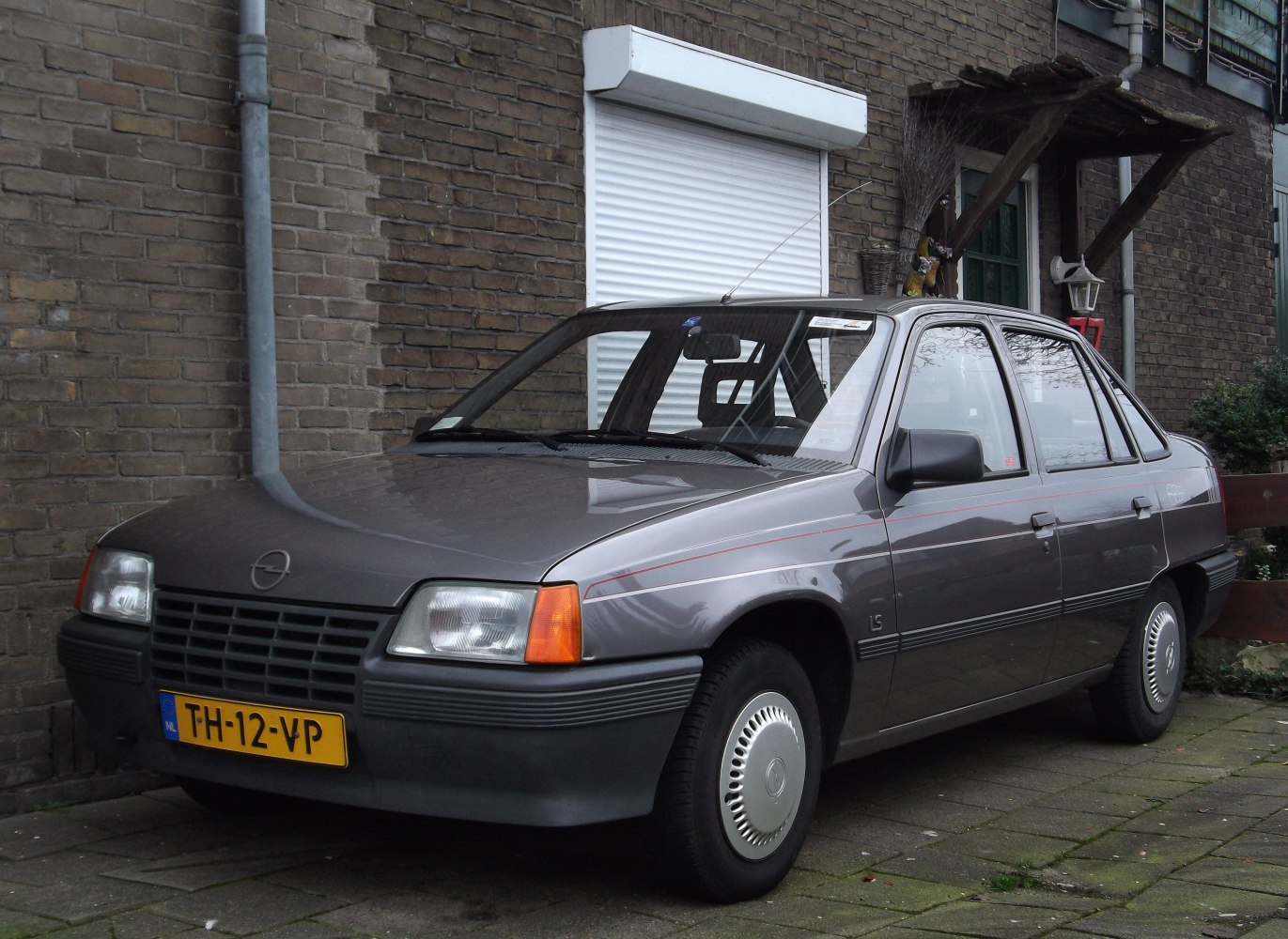 1980s compact sedan with rectangular headlights and black grille.