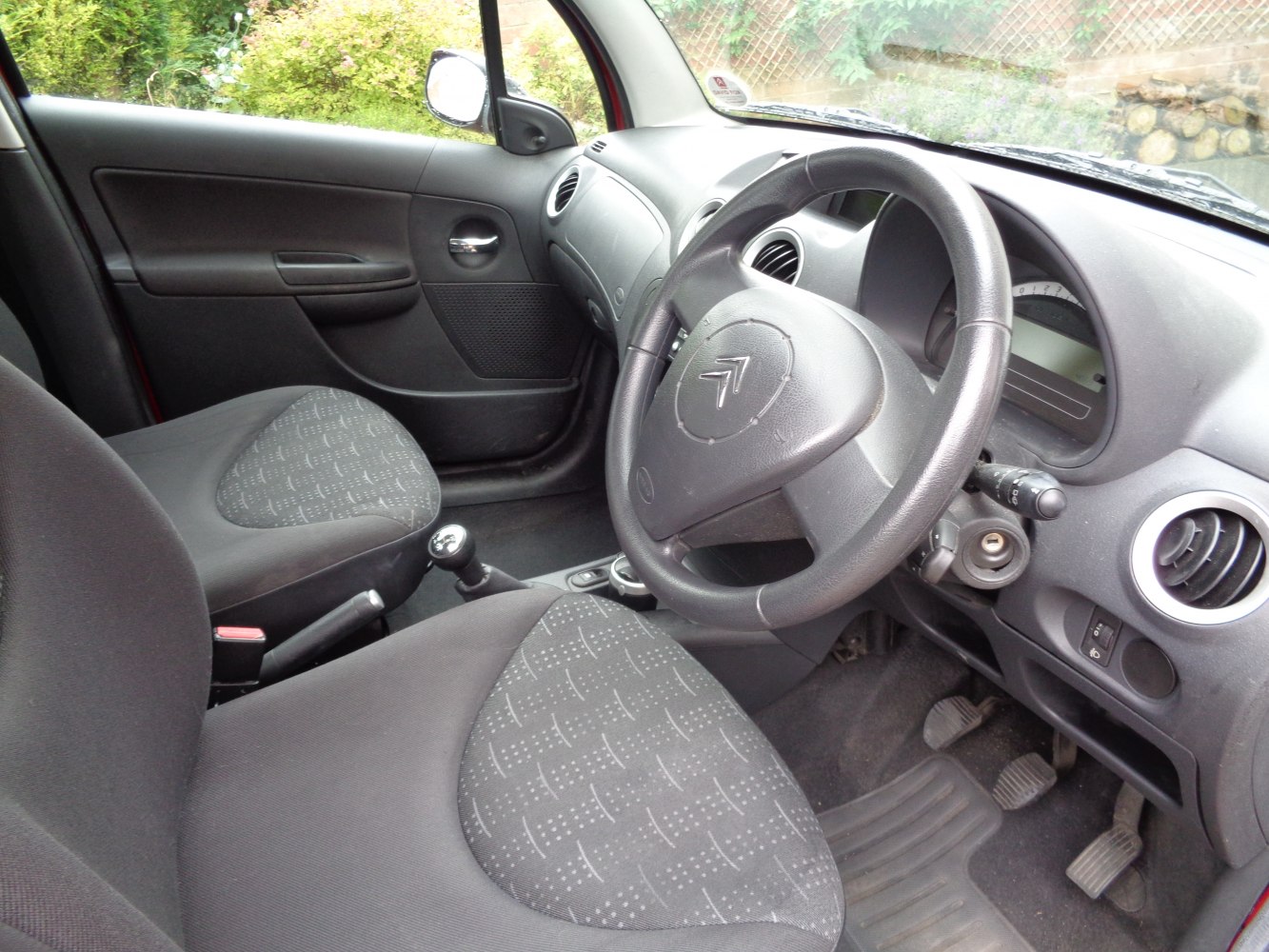 Dashboard, steering wheel, fabric front seats, and manual gearstick.
