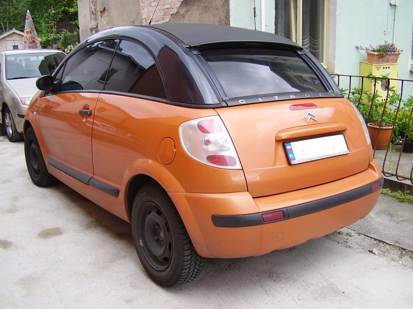Orange compact hatchback with black roof and large rear window