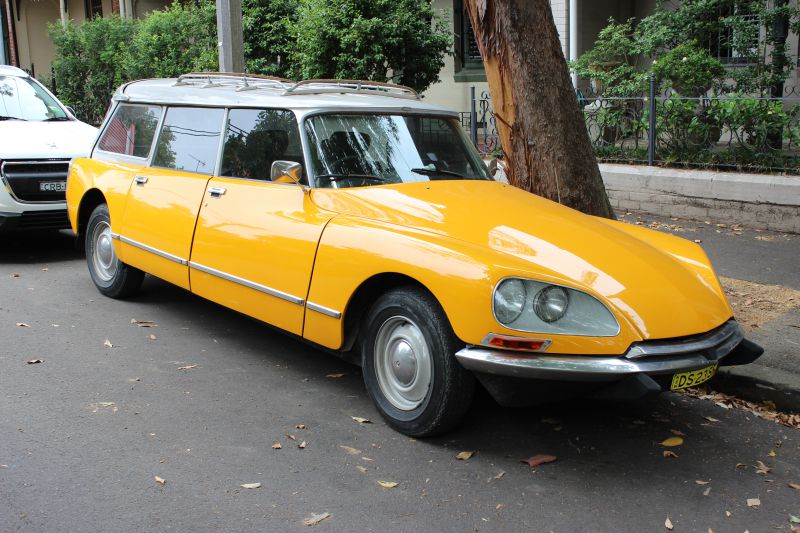 Yellow vintage aerodynamic station wagon with long roof and chrome trim