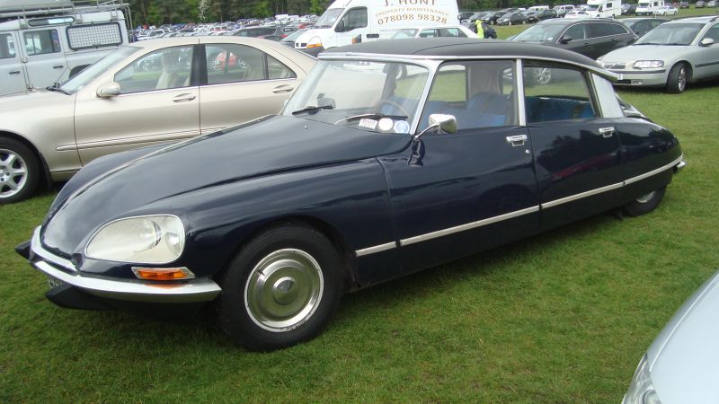 Side profile of a classic aerodynamic sedan with chrome trim and smooth body lines.