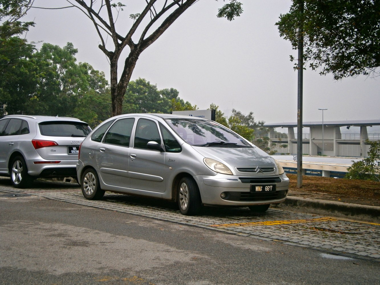 Silver compact multi-purpose vehicle with rounded design and panoramic windshield