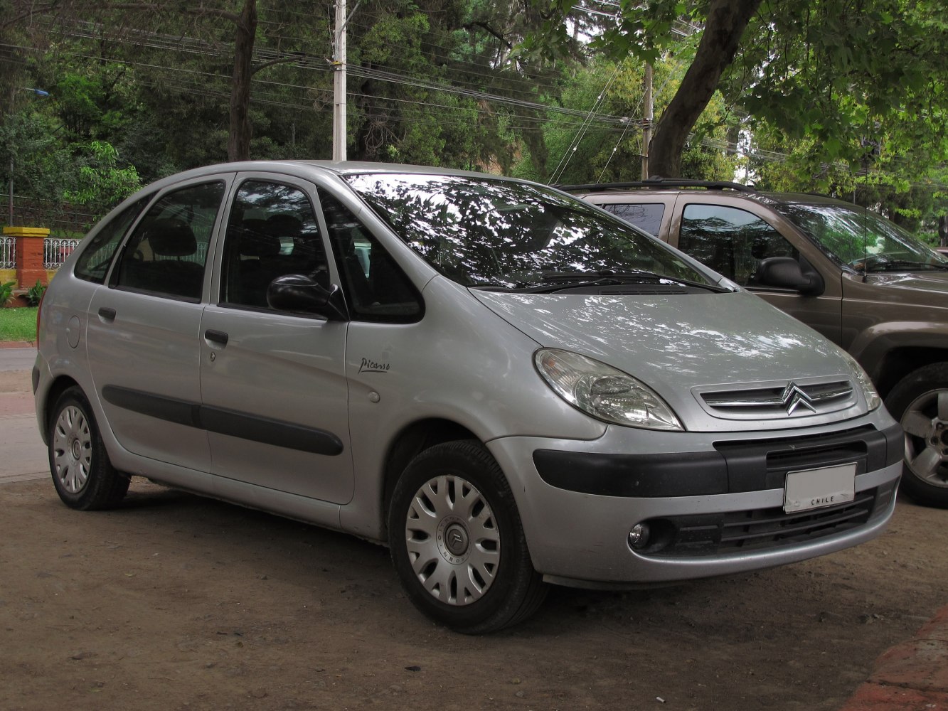 Rounded front, black bumpers, multi-door hatchback side view