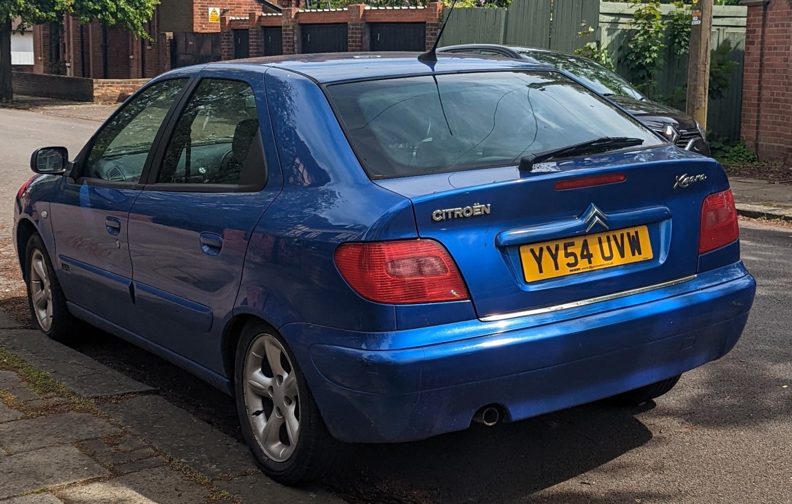 Rear view of blue hatchback with distinct taillights and alloy wheels