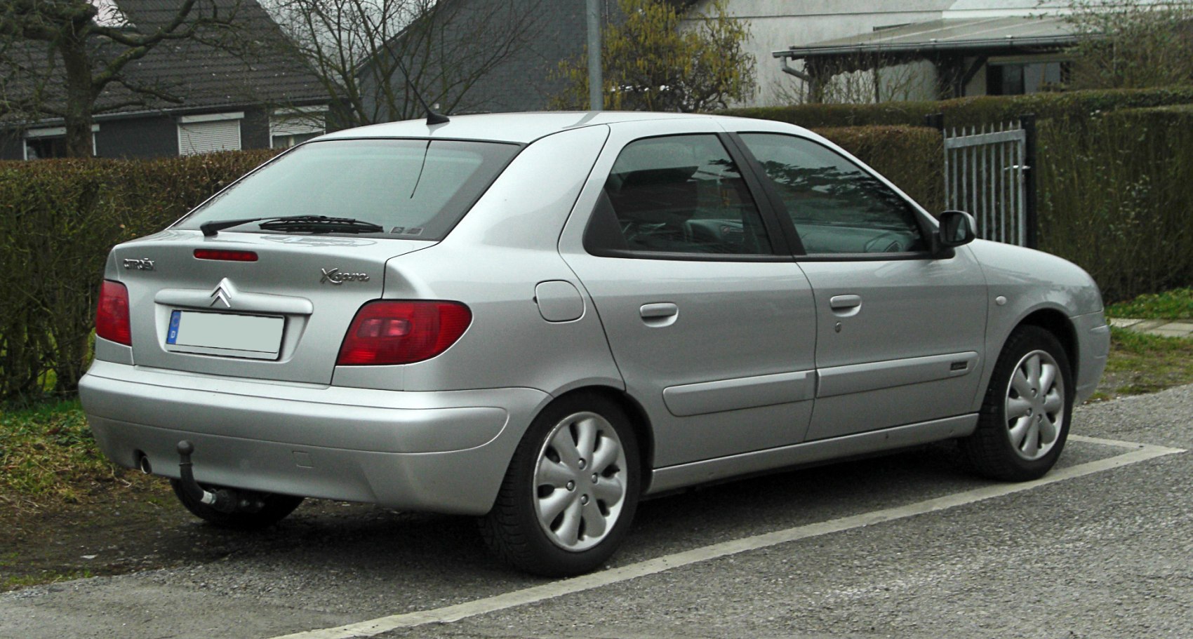 Silver sedan with rear taillights and tow hook visible