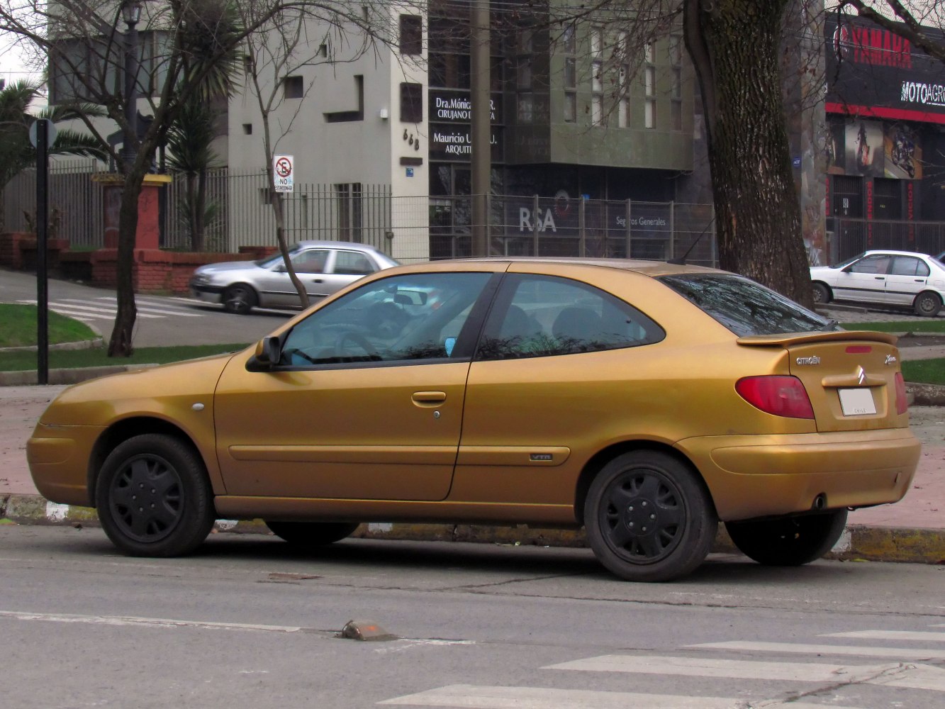 Yellow sporty compact coupe with rear spoiler and black wheels