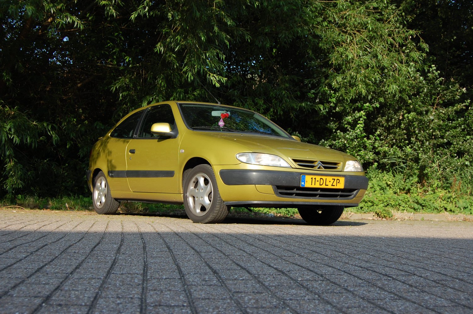 Front side view of a compact coupe with aerodynamic design and distinctive headlights