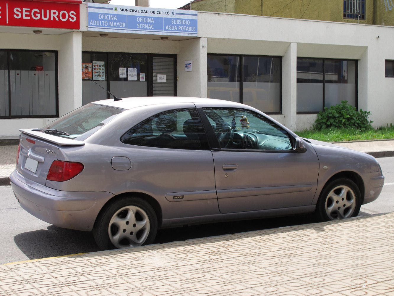 Side profile of compact coupe with rear spoiler and alloy wheels