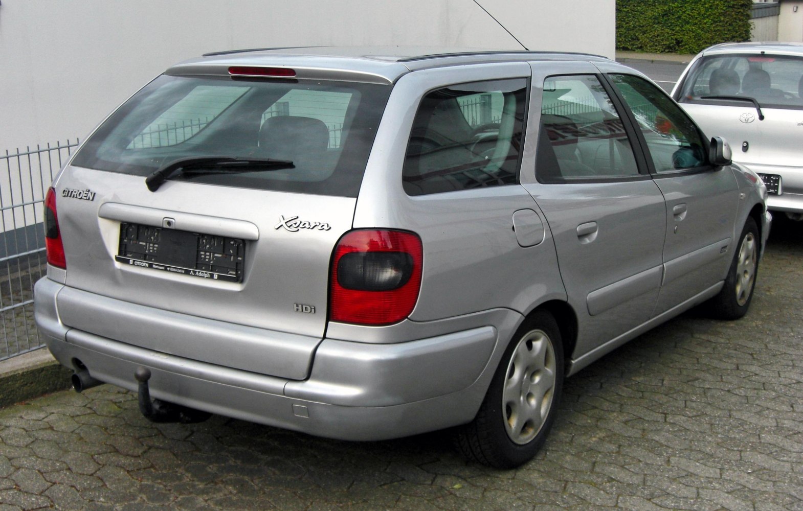 Rear view of silver station wagon with distinctive tail lights and rear hatch