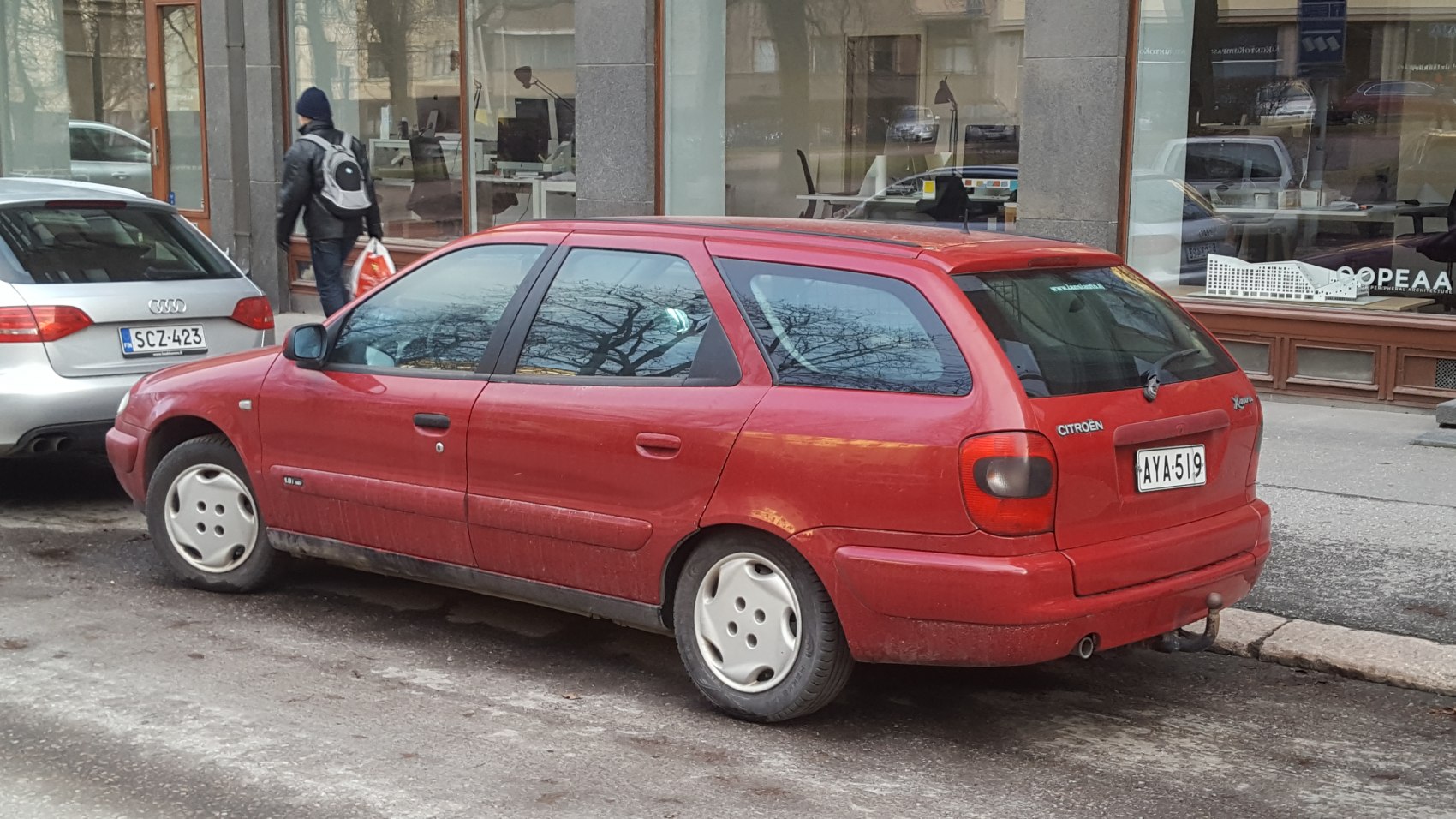 Red estate car with distinctive tail lights and roof rails