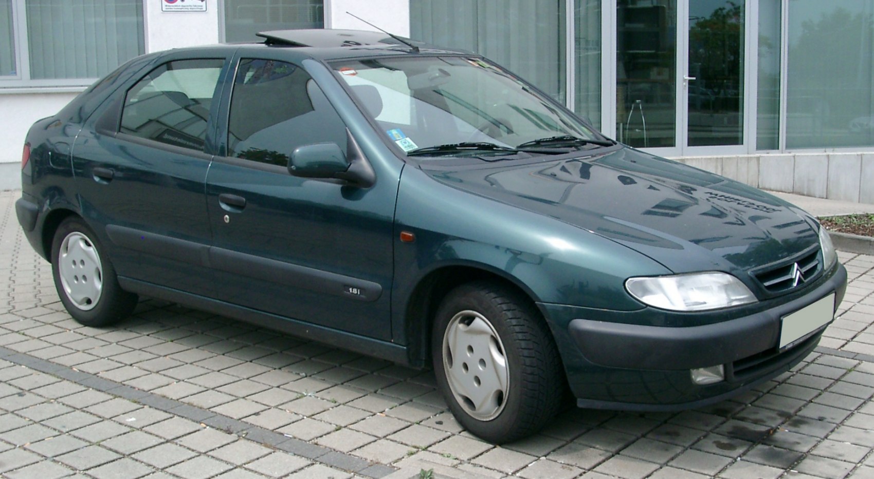 Front side view of a compact sedan with aerodynamic design and body panels.