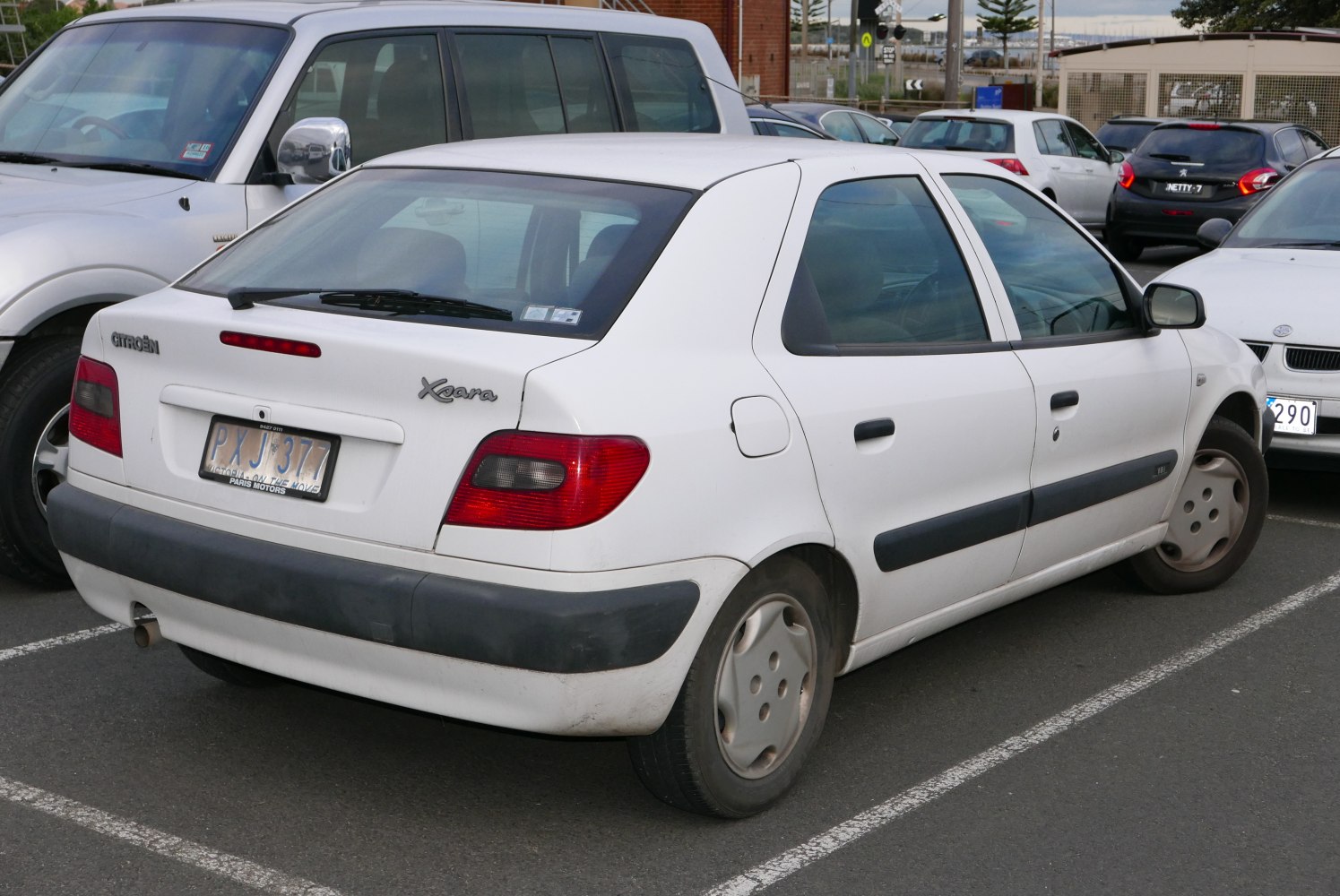 Rear view of white hatchback with distinct taillights and rear window wiper