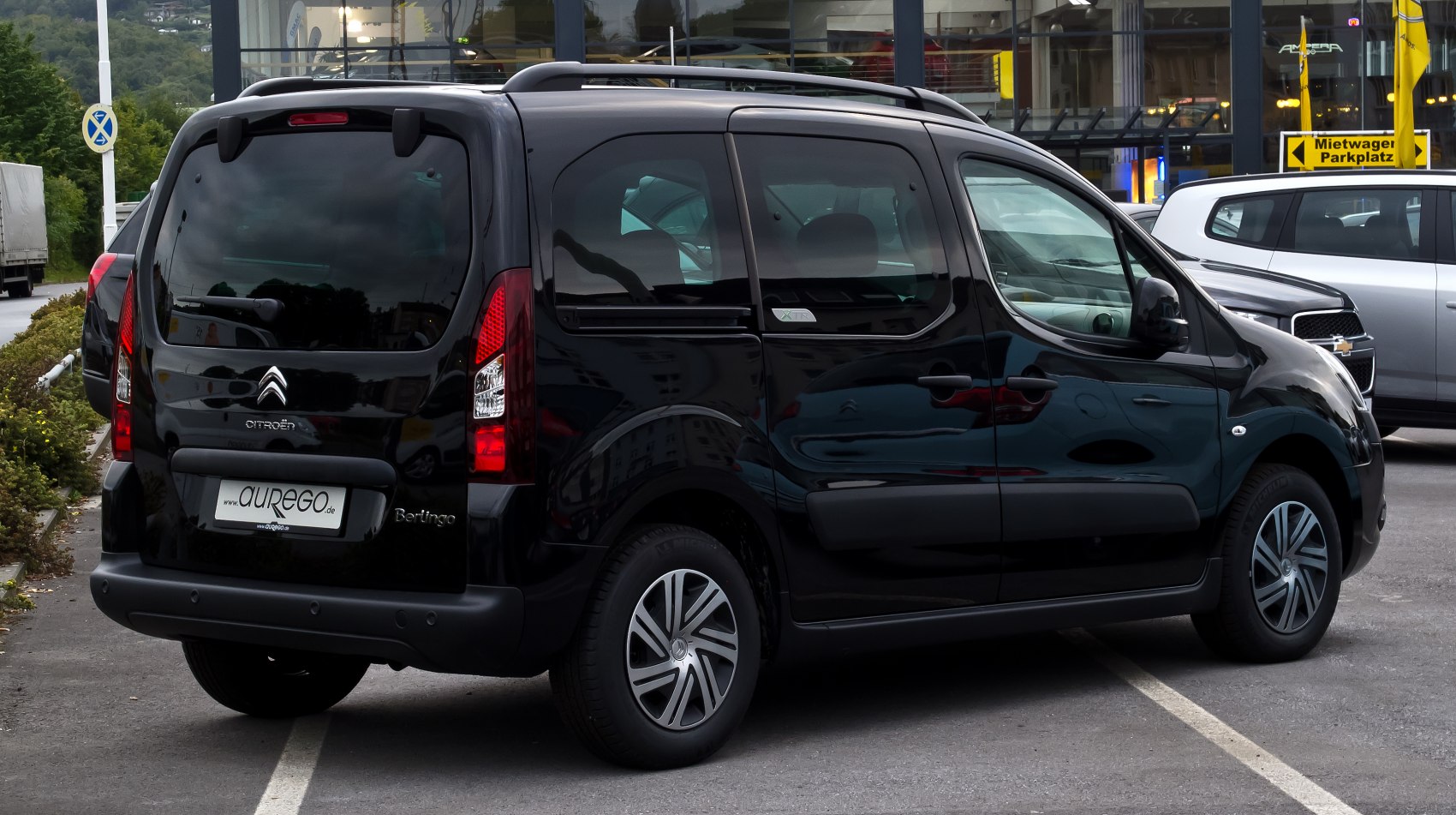 Rear-side view of black compact van with roof rails and alloy wheels